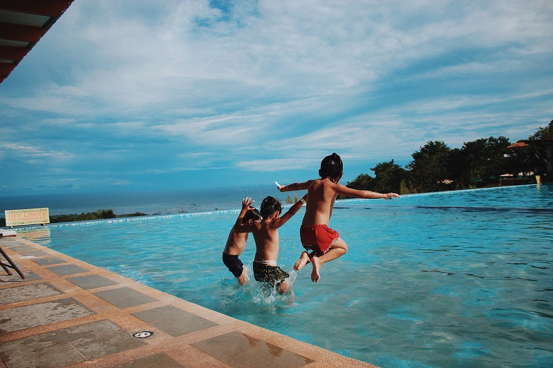 enfants-qui-sautent-dans-la-piscine-vacances