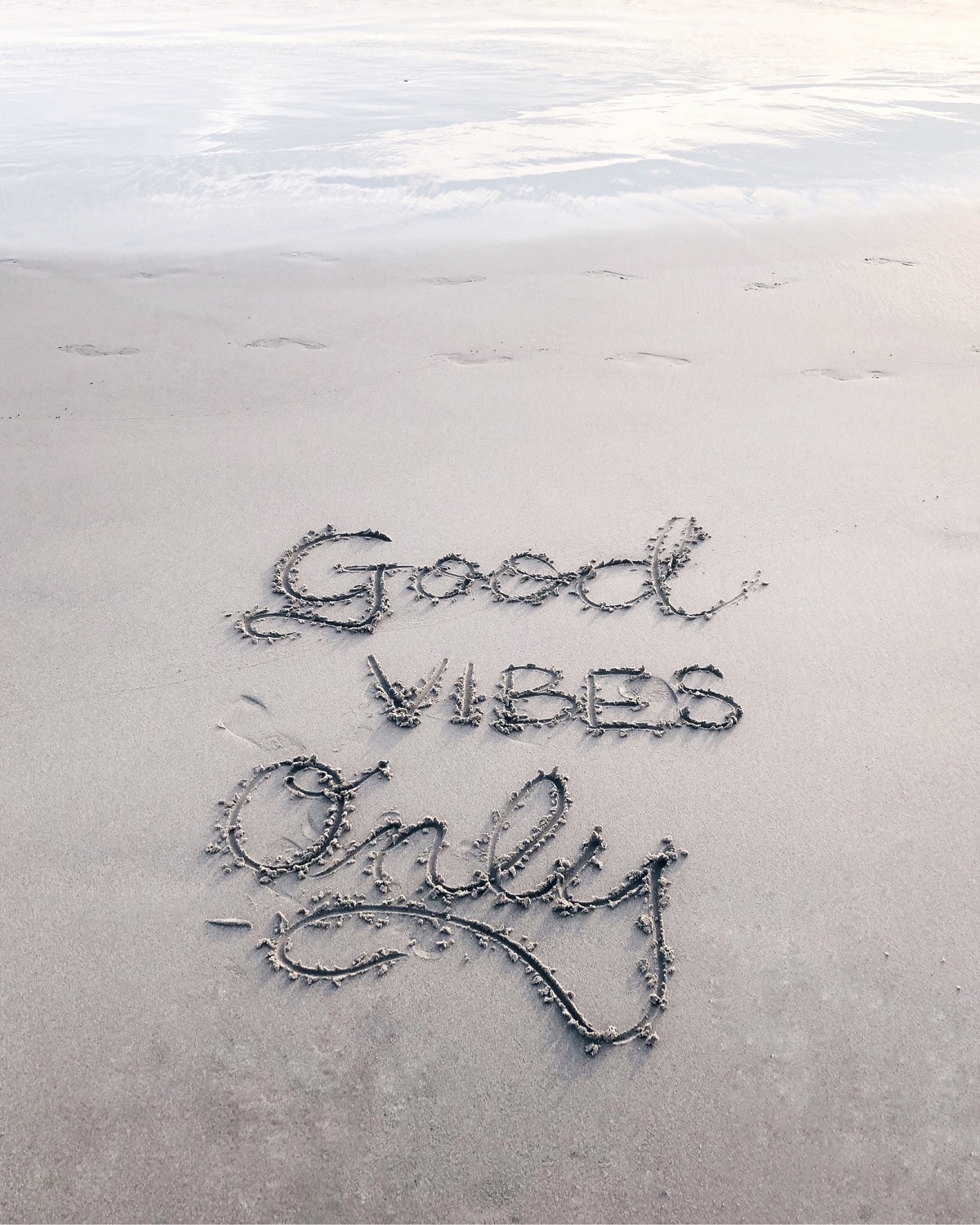 good vibes only ecrit sur dans le sable sur la plage